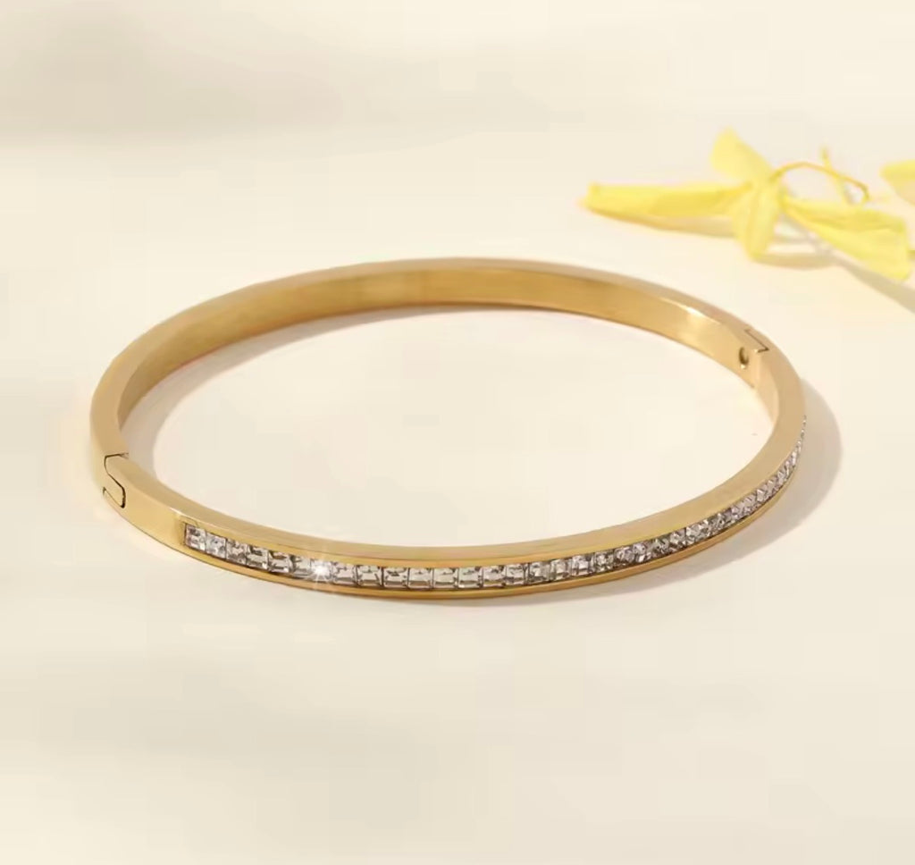 The Éclat Cuff bracelet with small diamonds on a light beige background