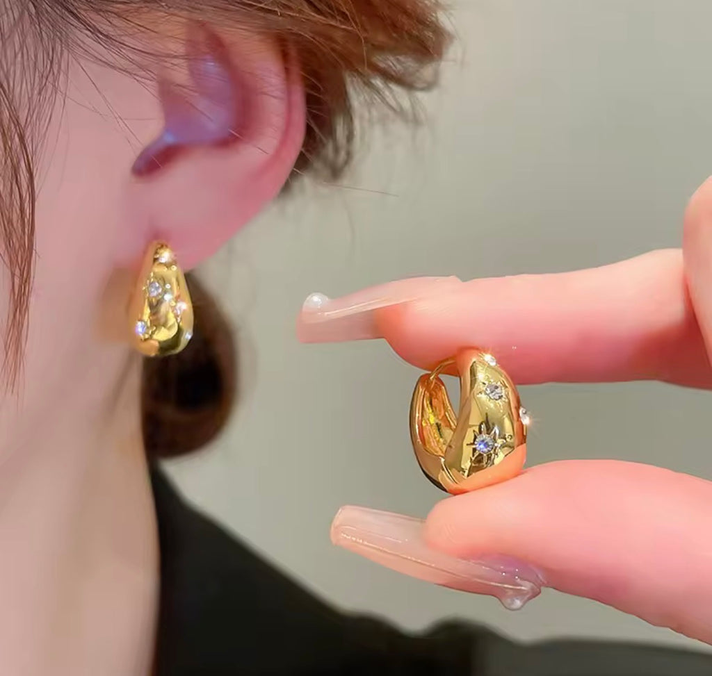 Woman Wearing The Astra Chunky Gold Star Hoop Earrings