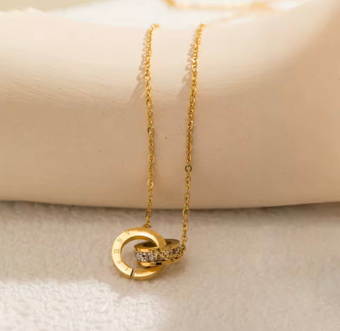 Shop The Eterna Necklace – a stainless steel interlocking circle pendant with sparkling cubic zirconia. Elegant, meaningful and perfect for everyday wear.
