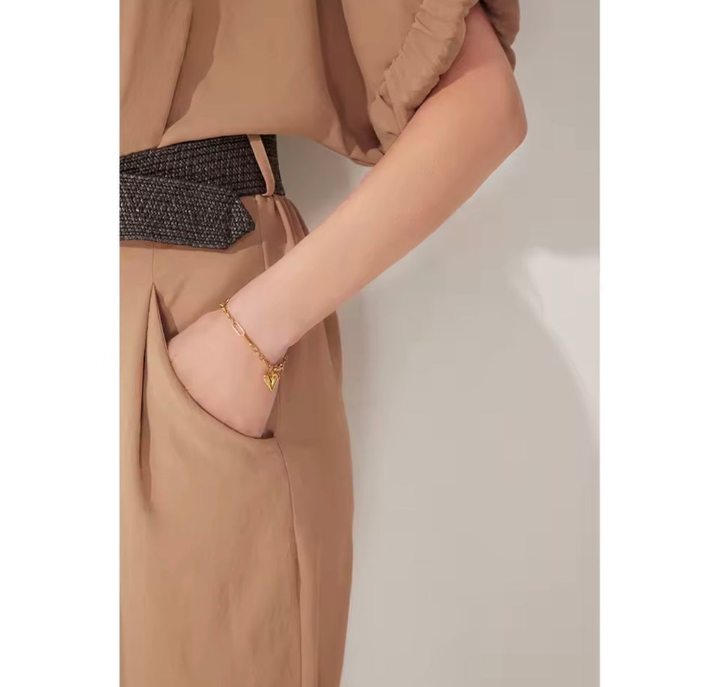 Woman wearing The Noémie gold heart charm bracelet