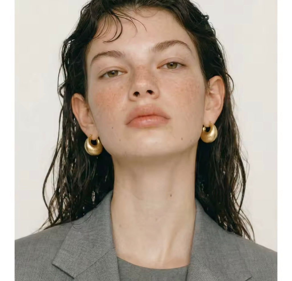 Woman wearing The Savara chunky gold hoop earrings