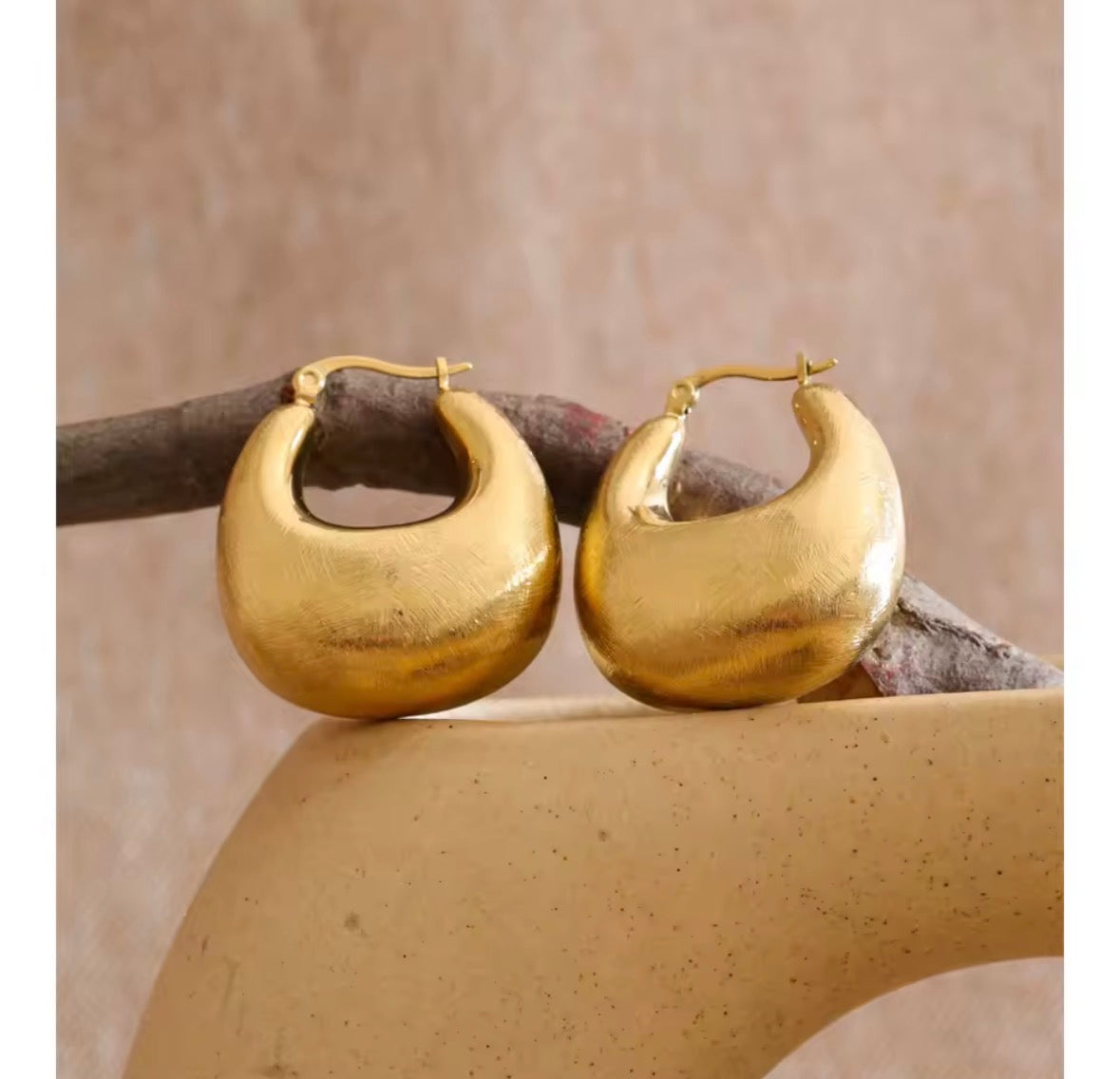 The Savara chunky gold hoop earrings displayed on a neutral background